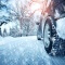 Car tires on winter road covered with snow. Vehicle on snowy alley in the morning at snowfall